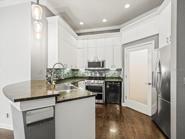 kitchen with kitchen peninsula, sink, pendant lighting, and appliances with stainless steel finishes