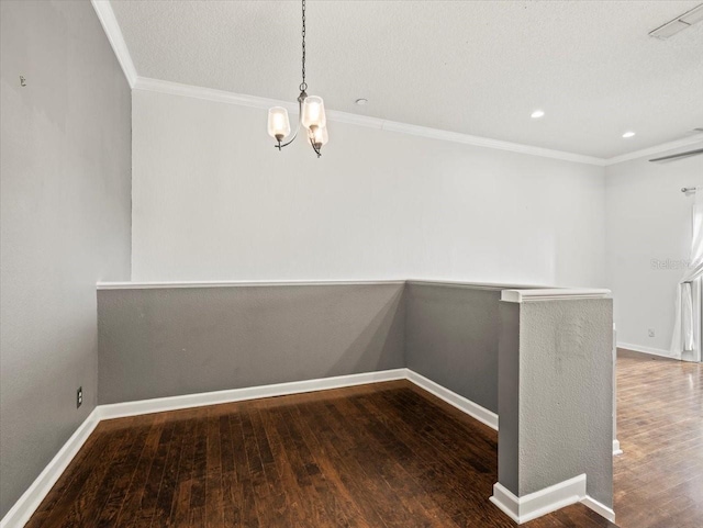 unfurnished dining area featuring hardwood / wood-style flooring, a notable chandelier, ornamental molding, and a textured ceiling