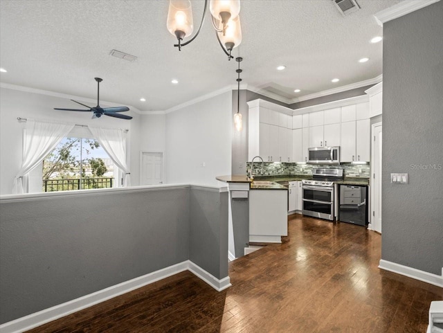 kitchen featuring pendant lighting, dark wood-type flooring, white cabinetry, kitchen peninsula, and stainless steel appliances