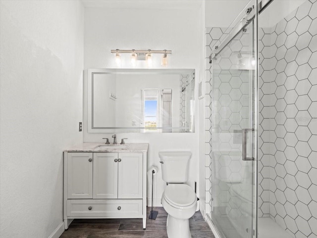 bathroom featuring vanity, wood-type flooring, an enclosed shower, and toilet