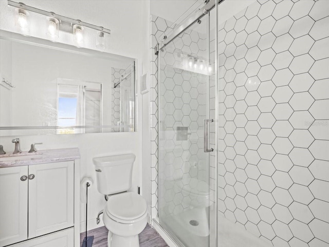 bathroom with vanity, hardwood / wood-style flooring, toilet, and an enclosed shower