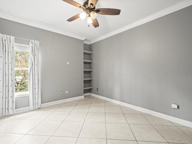 tiled empty room with ceiling fan, ornamental molding, and built in shelves