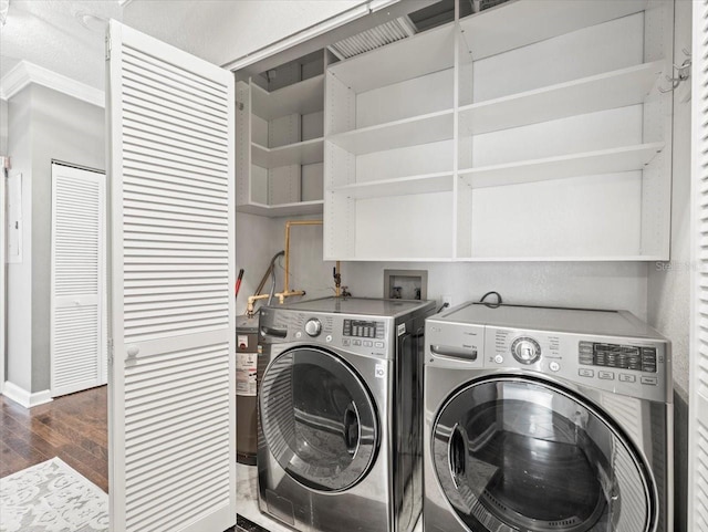 washroom featuring ornamental molding, dark hardwood / wood-style floors, and independent washer and dryer