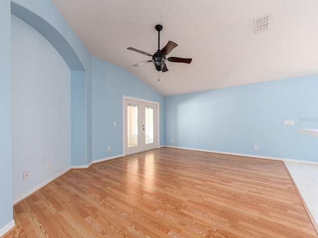 unfurnished room with ceiling fan, light hardwood / wood-style floors, lofted ceiling, and french doors