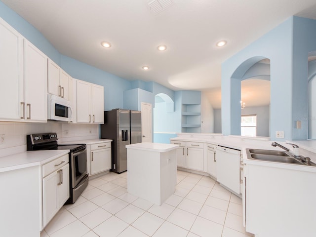 kitchen with a center island, backsplash, sink, appliances with stainless steel finishes, and kitchen peninsula