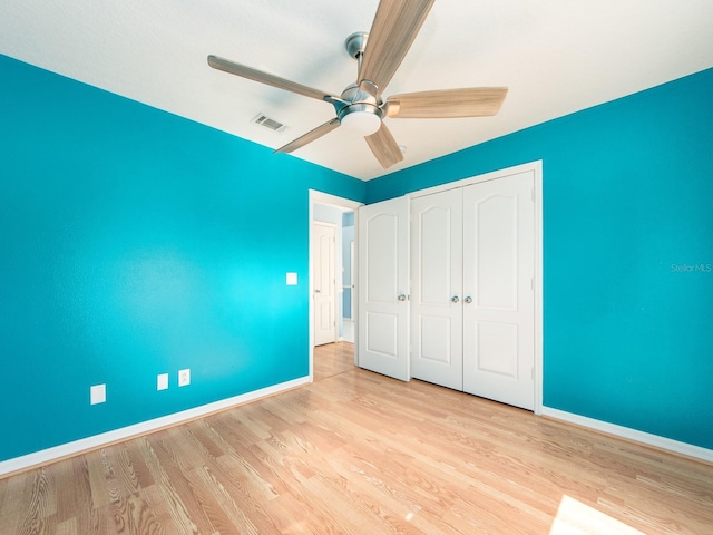 unfurnished bedroom with ceiling fan, a closet, and light wood-type flooring