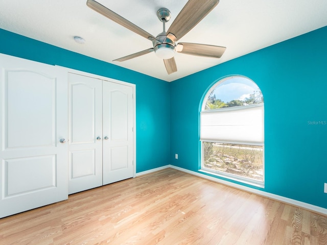 unfurnished bedroom with ceiling fan, a closet, and light hardwood / wood-style flooring