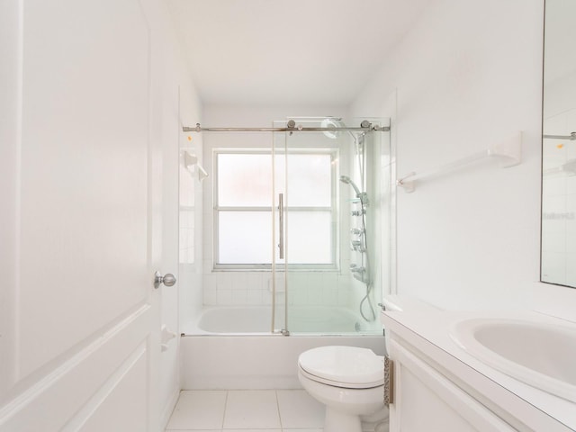 full bathroom with combined bath / shower with glass door, vanity, tile patterned flooring, and toilet