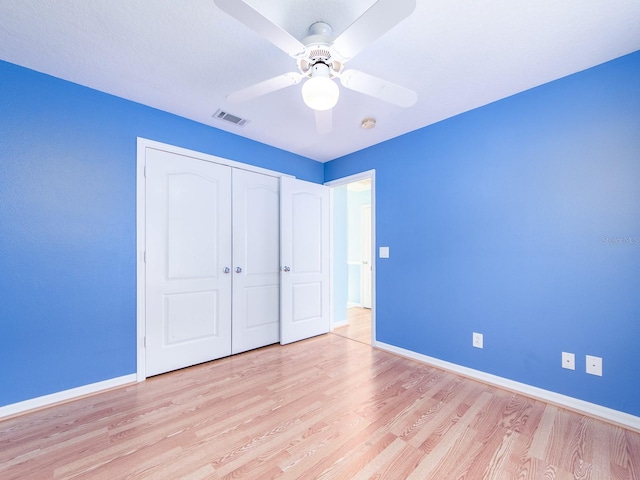 unfurnished bedroom featuring light hardwood / wood-style flooring, a closet, and ceiling fan