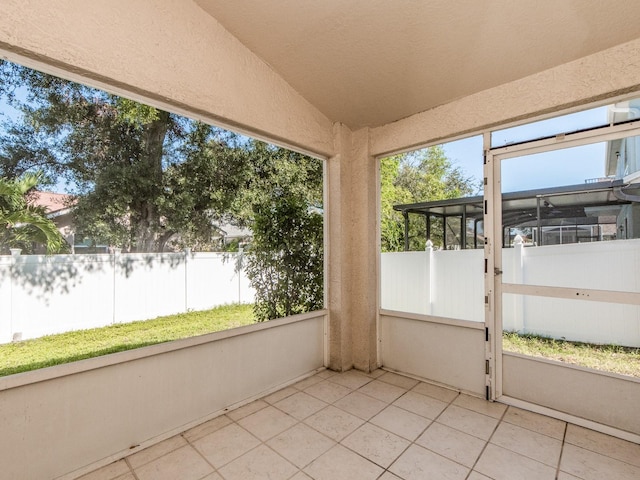 unfurnished sunroom featuring vaulted ceiling