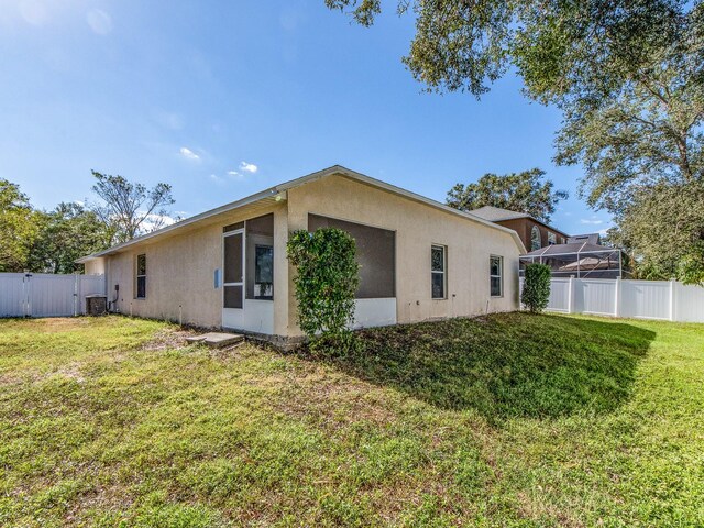 view of side of property with a yard and central air condition unit