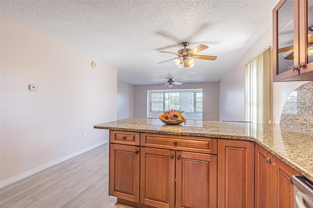 1900 68th St N Unit 301, Saint Petersburg, FL 33710 - kitchen featuring a peninsula, light wood-style flooring, brown cabinets, a textured ceiling, and ceiling fan