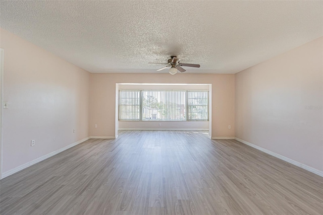 unfurnished room featuring ceiling fan, light hardwood / wood-style floors, and a textured ceiling