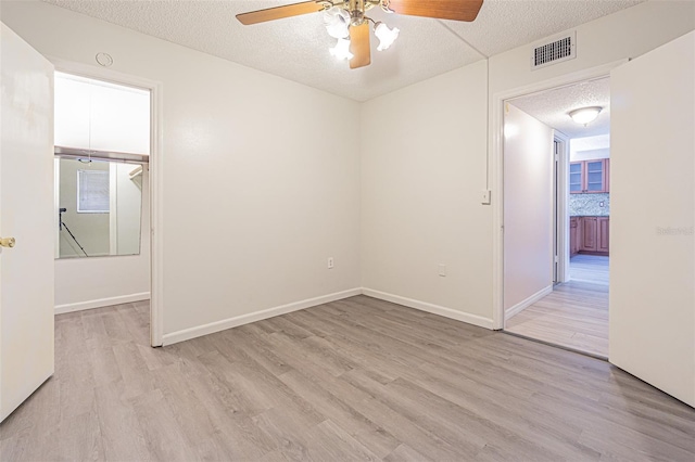 1900 68th St N Unit 301, Saint Petersburg, FL 33710 - unfurnished room featuring a ceiling fan, light wood finished floors, a textured ceiling, and baseboards
