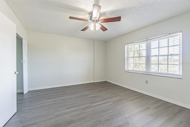 1900 68th St N Unit 301, Saint Petersburg, FL 33710 - empty room featuring a textured ceiling, ceiling fan, wood finished floors, and baseboards