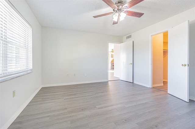 empty room featuring hardwood / wood-style floors, a textured ceiling, and ceiling fan