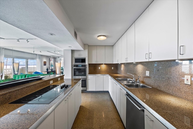 kitchen with decorative backsplash, a textured ceiling, stainless steel appliances, sink, and white cabinets