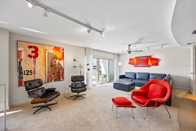 carpeted living room with ceiling fan, a textured ceiling, and track lighting