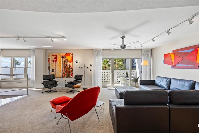 carpeted living room with ceiling fan, a healthy amount of sunlight, a textured ceiling, and track lighting