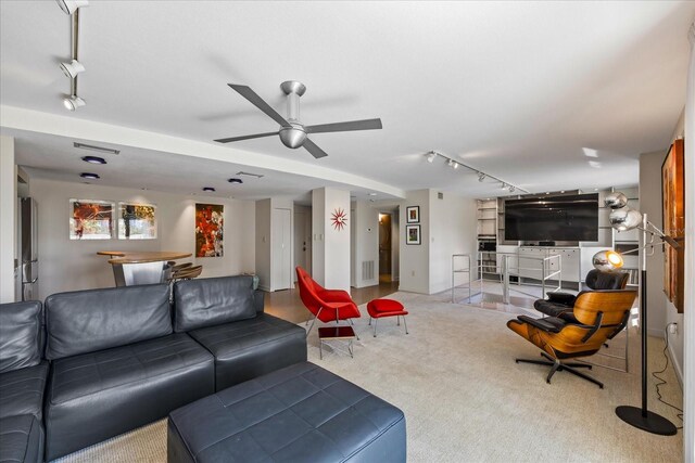 carpeted living room with ceiling fan and rail lighting