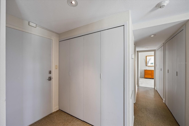 hall featuring a textured ceiling