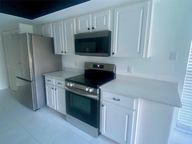 kitchen with white cabinets, light tile patterned floors, and stainless steel appliances