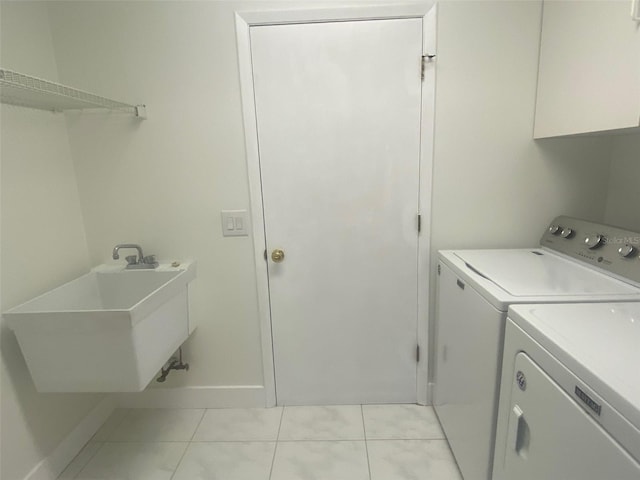 washroom featuring light tile patterned floors, washer and clothes dryer, and sink