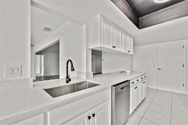 kitchen featuring sink, light tile patterned floors, dishwasher, white cabinetry, and light stone countertops