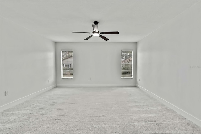 empty room featuring a wealth of natural light, light colored carpet, and ceiling fan