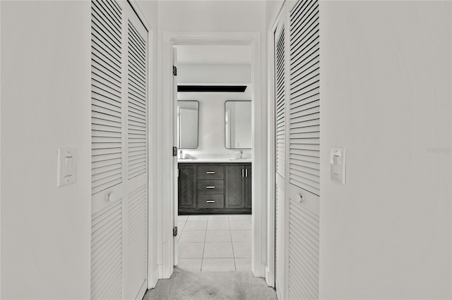 corridor with sink and light colored carpet