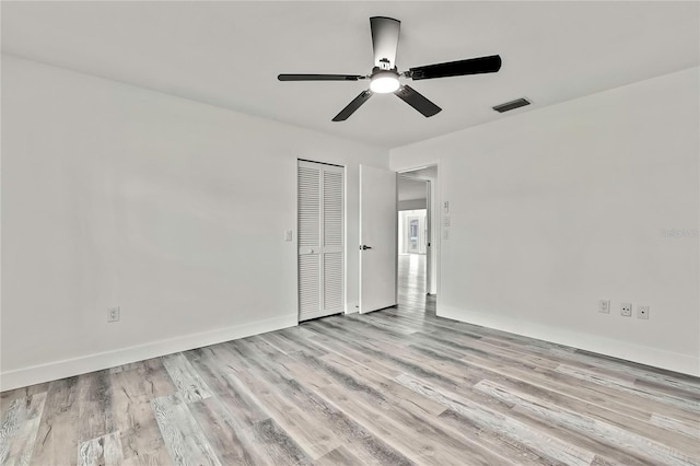 empty room with ceiling fan and light hardwood / wood-style floors