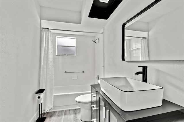 full bathroom featuring vanity, wood-type flooring, shower / bath combination with curtain, and toilet