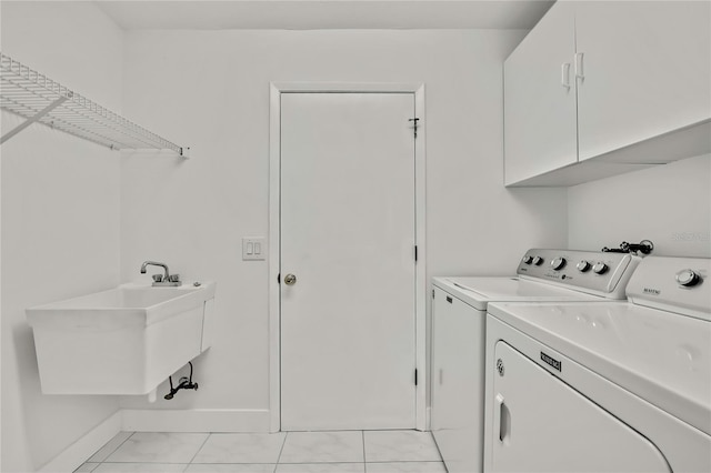 laundry area with cabinets, sink, washer and dryer, and light tile patterned floors