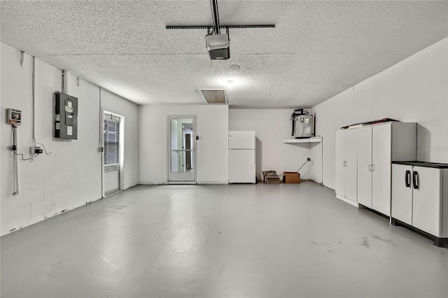 garage with a garage door opener, electric panel, water heater, and white refrigerator