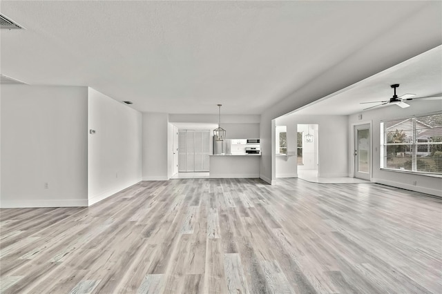 unfurnished living room featuring ceiling fan, light hardwood / wood-style flooring, and a textured ceiling