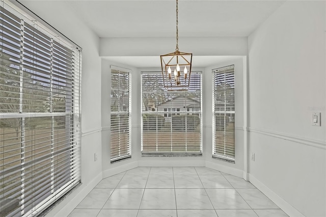 unfurnished dining area featuring light tile patterned floors and an inviting chandelier