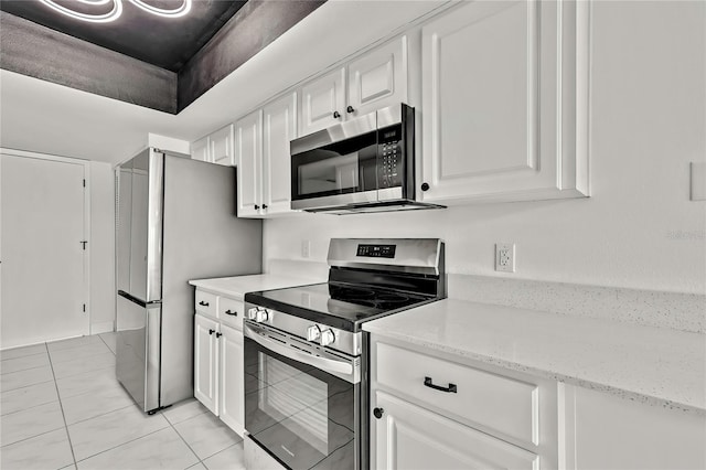 kitchen with light stone counters, appliances with stainless steel finishes, and white cabinets