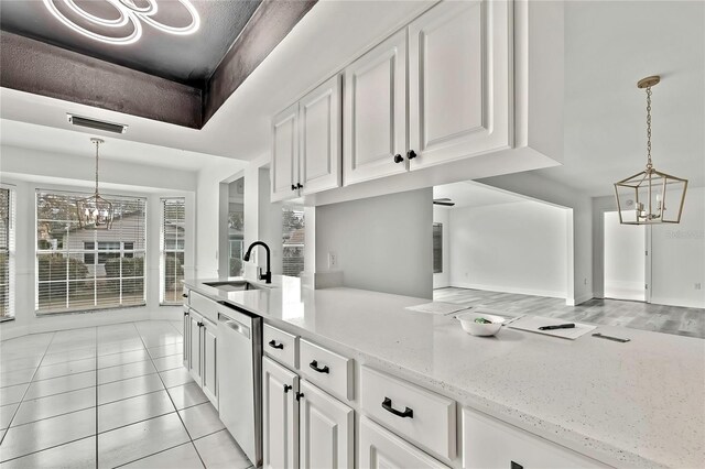 kitchen featuring sink, white cabinetry, a chandelier, stainless steel dishwasher, and pendant lighting