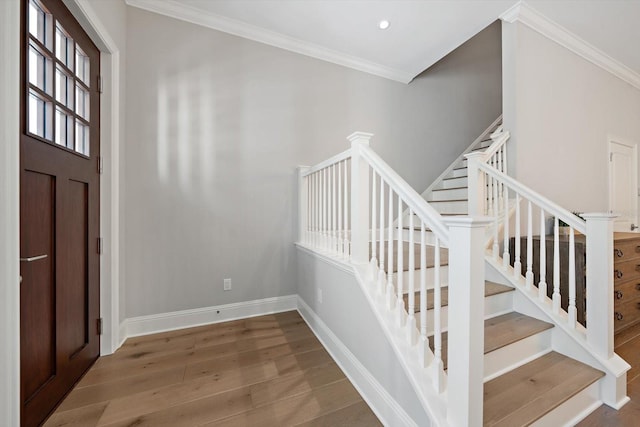 foyer entrance featuring hardwood / wood-style floors and crown molding