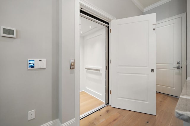 hall with light wood-type flooring and ornamental molding