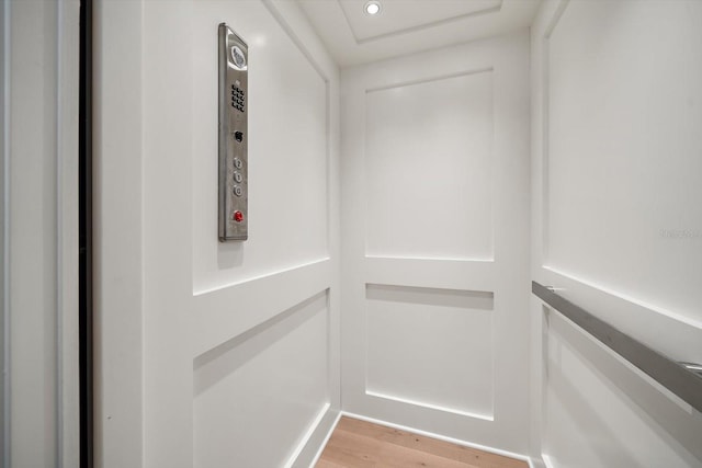 walk in closet featuring light wood-type flooring and elevator