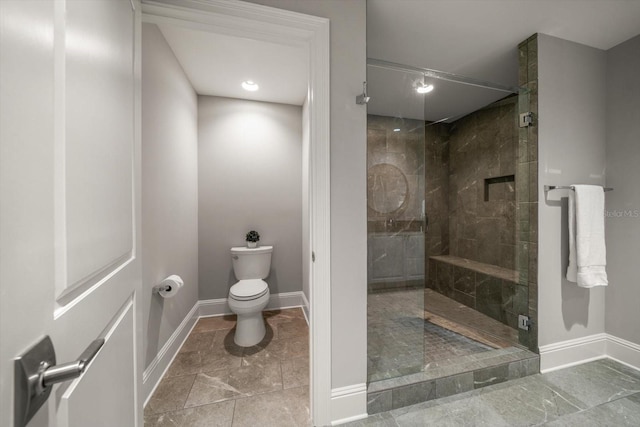 bathroom featuring toilet and a shower with shower door