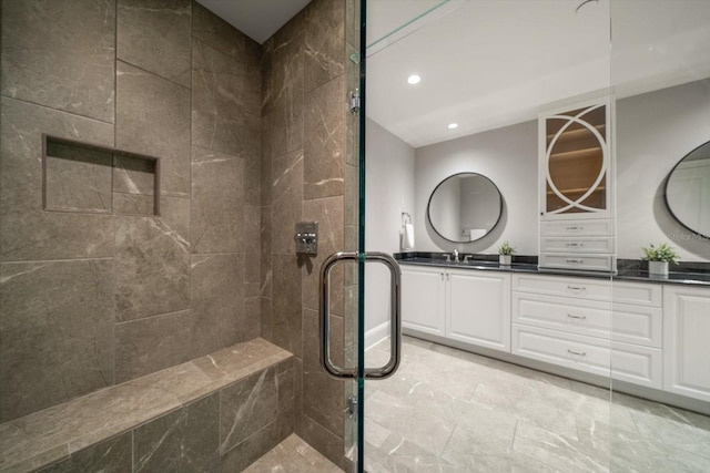 bathroom featuring tiled shower and vanity