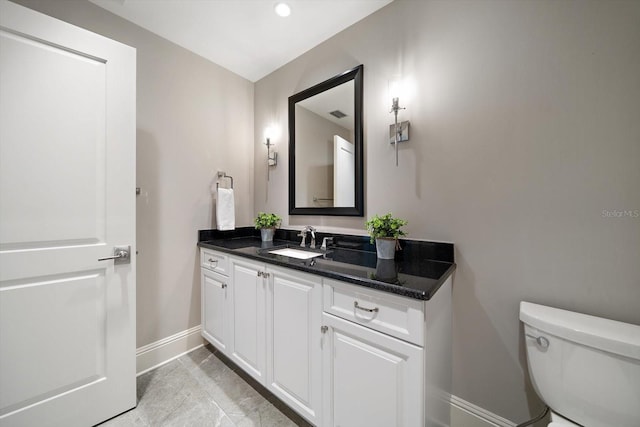 bathroom featuring tile patterned flooring, vanity, and toilet