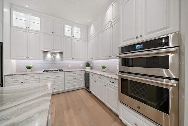 kitchen with wine cooler, white cabinetry, and appliances with stainless steel finishes