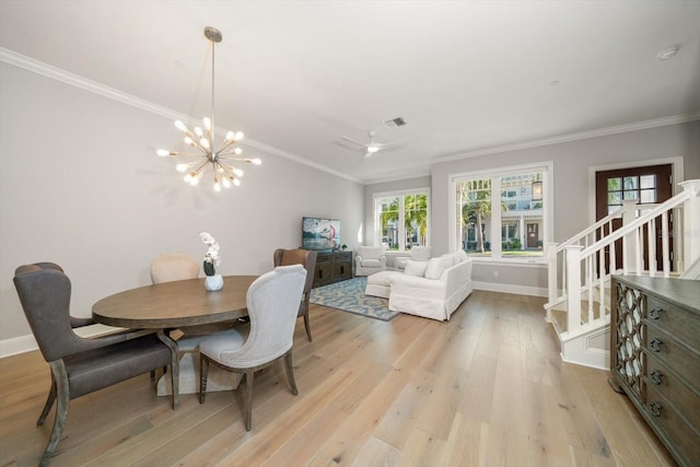 dining area featuring ceiling fan with notable chandelier, crown molding, and light hardwood / wood-style flooring