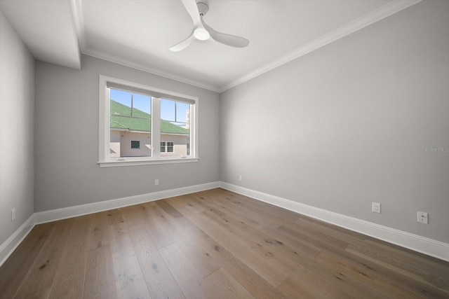 empty room featuring ceiling fan, ornamental molding, and hardwood / wood-style flooring