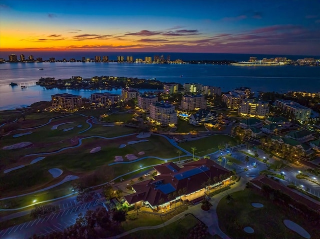 aerial view at dusk featuring a water view