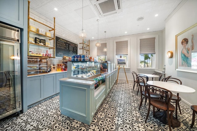 kitchen featuring blue cabinetry, a kitchen island with sink, and decorative light fixtures