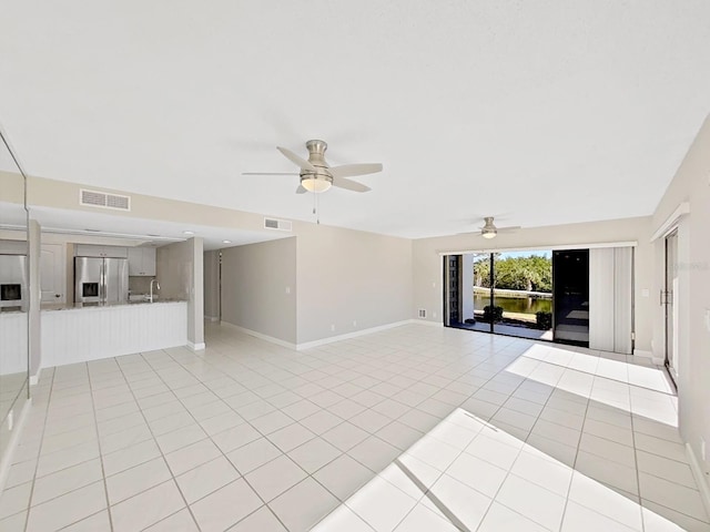 spare room featuring sink, ceiling fan, and light tile patterned flooring